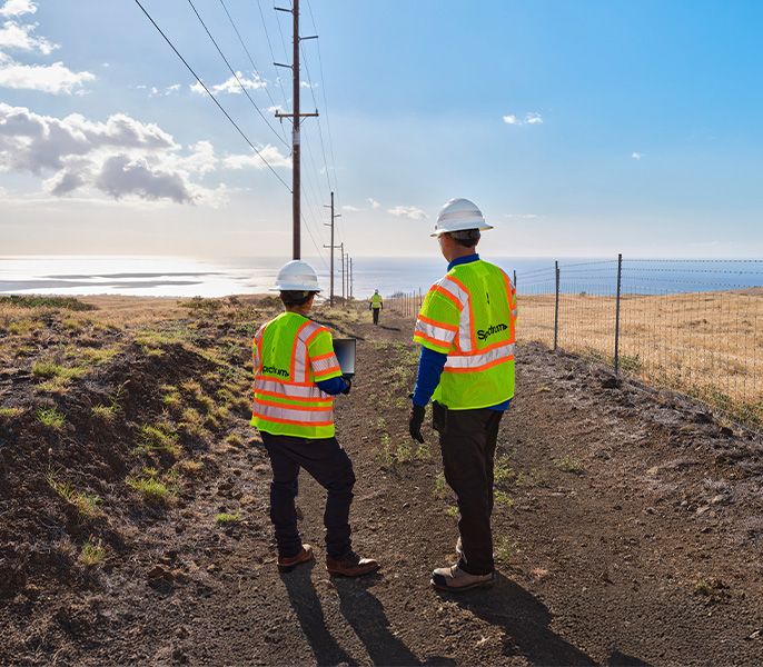 Two Spectrum field technicians survey an area for broadband expansion