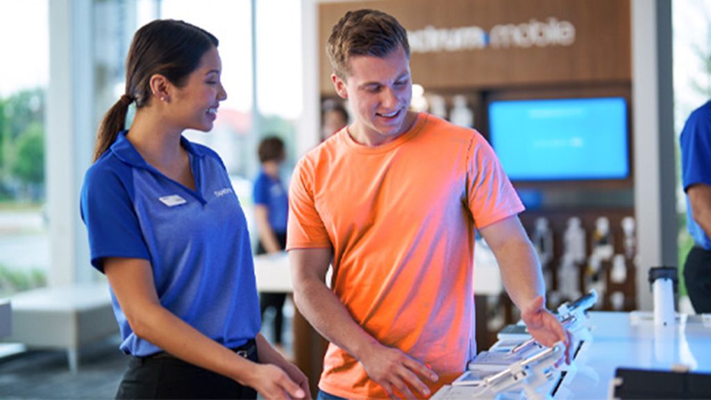 A Spectrum Mobile store employee helping a customer