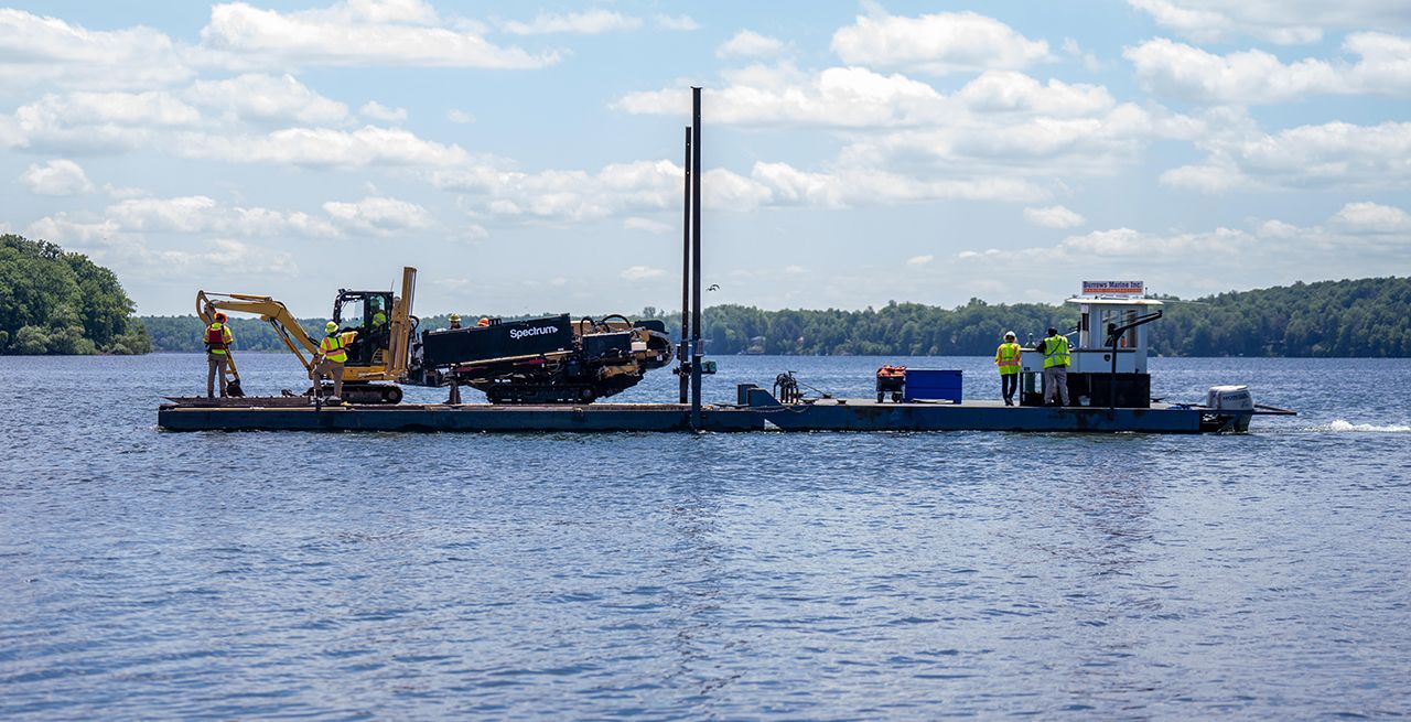 Spectrum field techs move equipment via docks at Sodus Bay