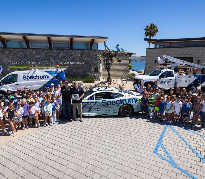 NASCAR driver Carson Hocevar poses with summer campers during a Spectrum community event