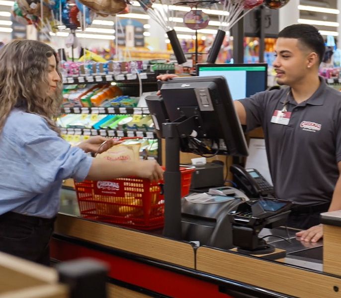 A clerk rings up a customer at Heritage Grocers