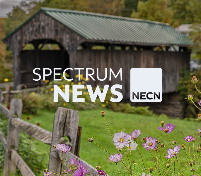 An old covered bridge with Spectrum News and NECN logos