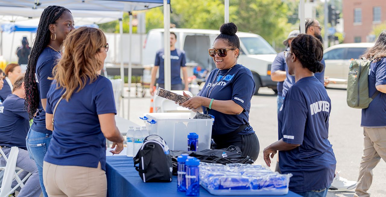 Spectrum volunteers distributing water bottles and other items at a community center event