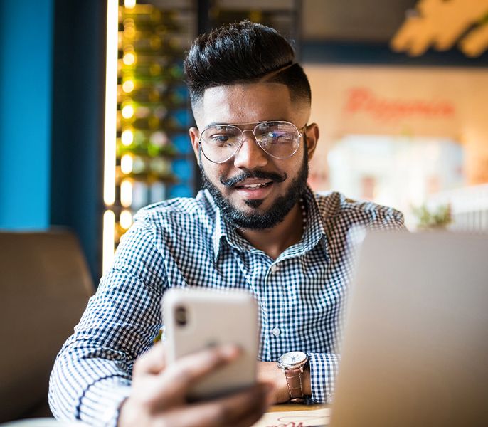 Man at cafe on two devices