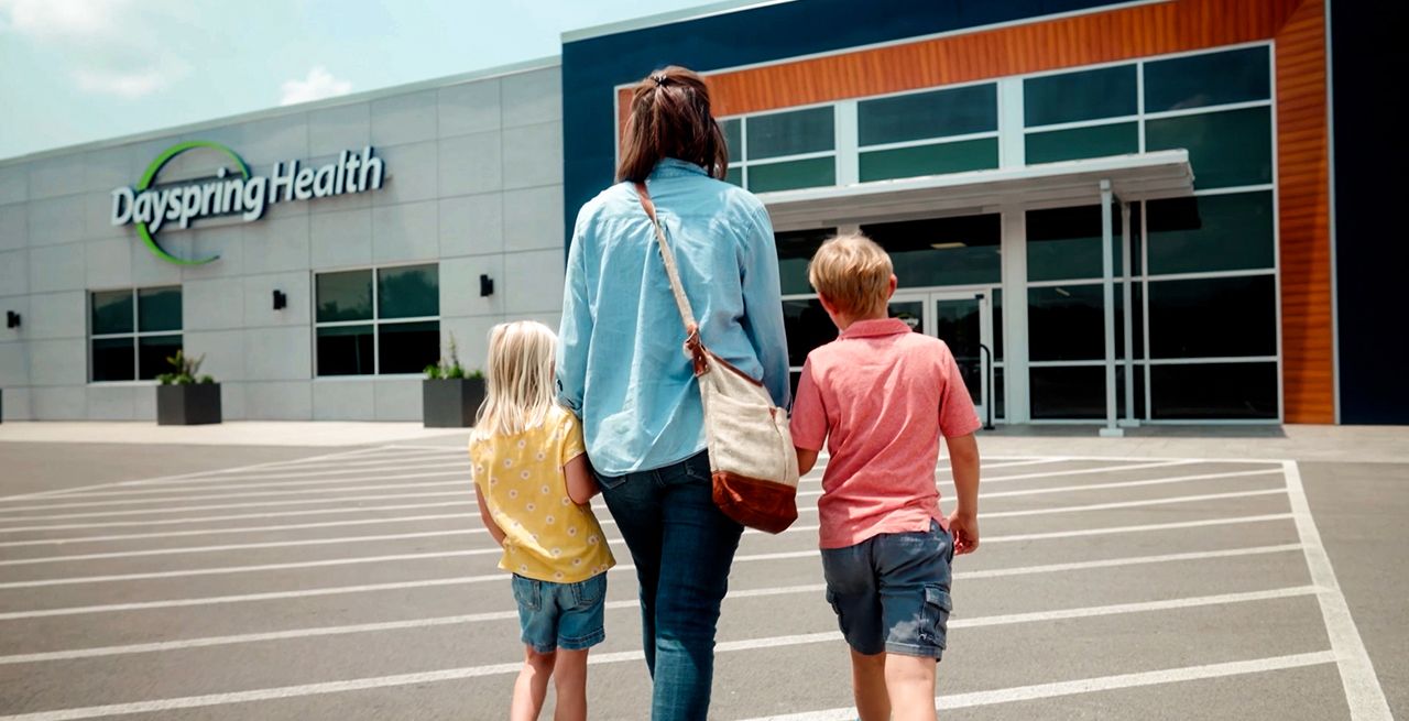 A family walking across a parking lot toward the Dayspring Health facility