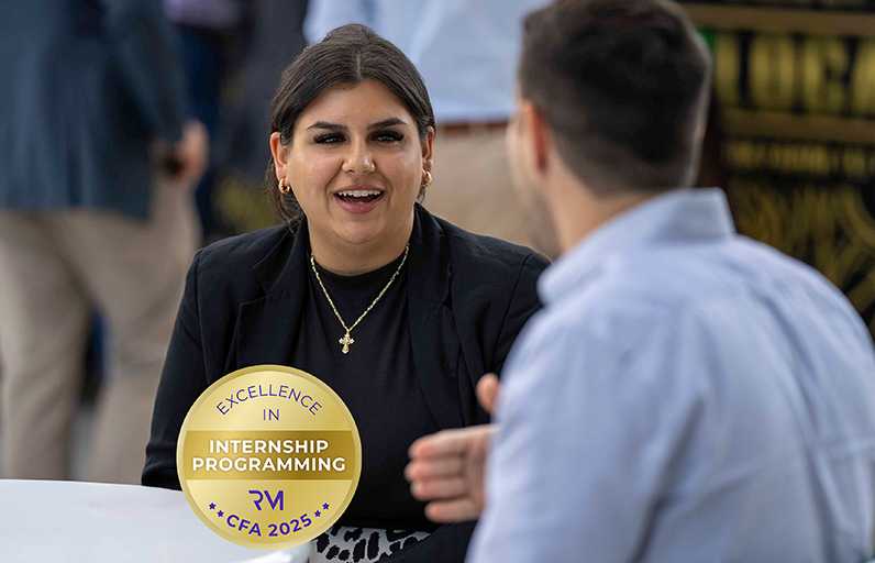 A Spectrum intern talking with her mentor during an event