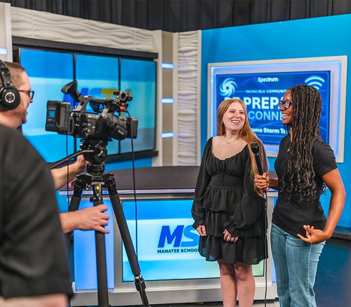 Two students on camera in a TV studio