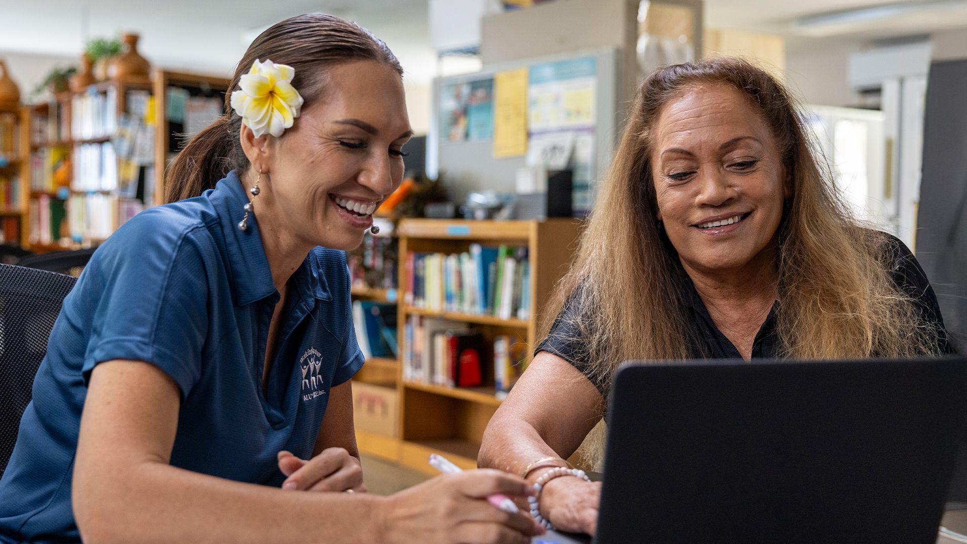 An instructor teaching an adult student in a computer lab