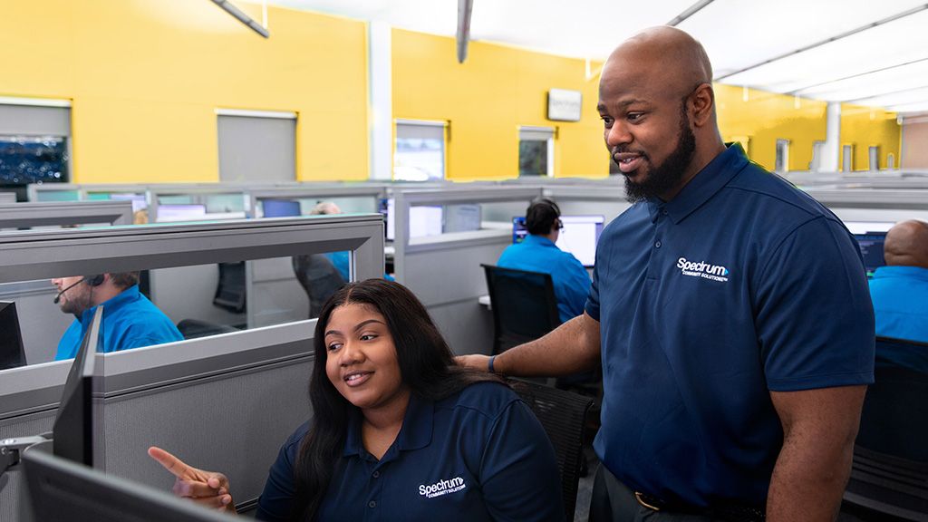 Two Spectrum call center employees working in a call center