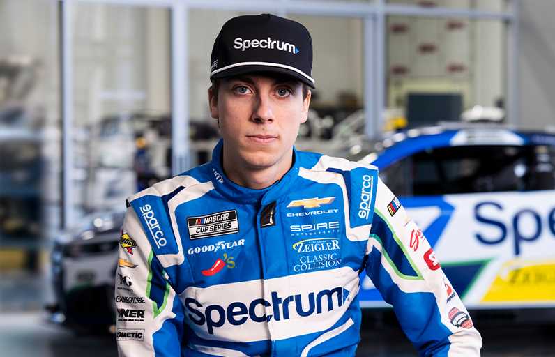 Carson Hocevar posing in front of the Spectrum car