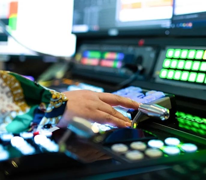 Someone using a control panel in a Spectrum Networks studio 