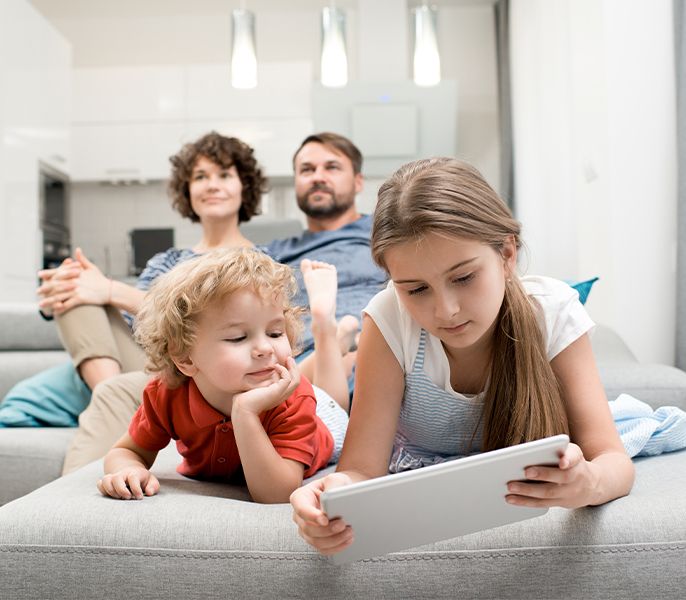 Parents watching TV and kids on device