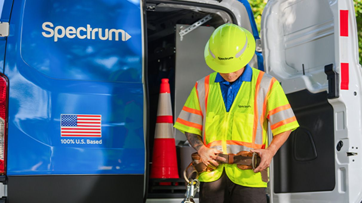 A Spectrum technician working at the back of his Spectrum van, rear door open