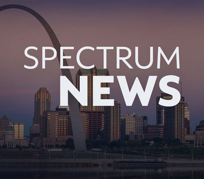 Spectrum News logo with St. Louis city skyline in background at dusk