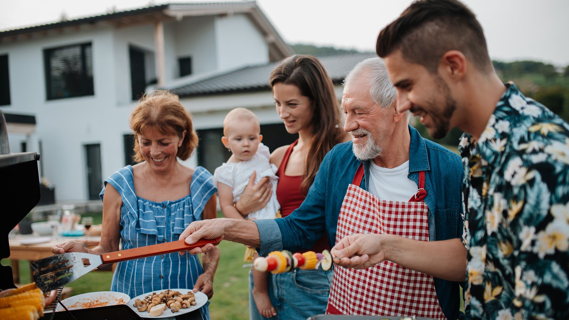 A family having a backyard cookout with a baby in the photo