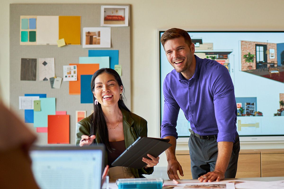 A pair of small business owners smiling in their place of business